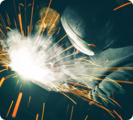 An image of a welder with sparks coming out of his mouth, showcasing the expertise and craftsmanship of a metal solutions provider.