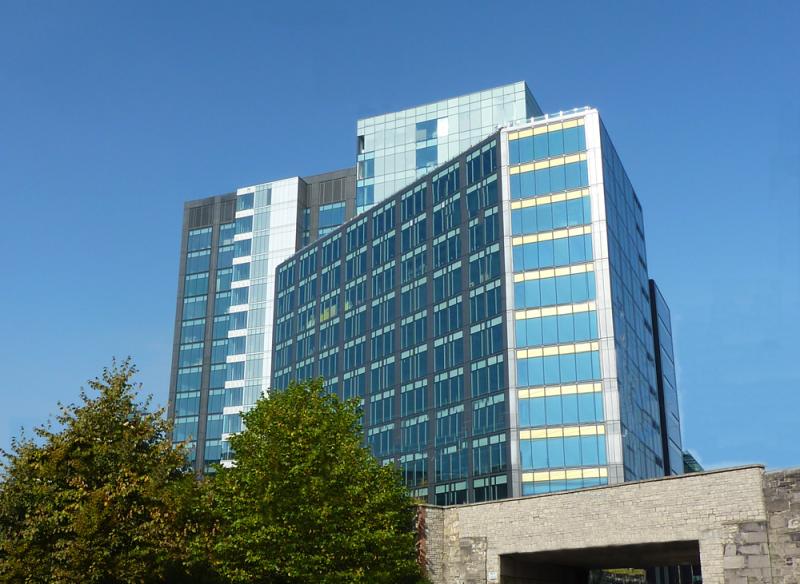 An office building with a large glass window offering metal solutions and laser cutting services for steel manufacturers.