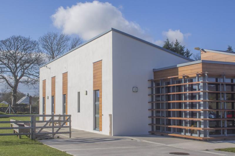 The exterior of a modern building with a wooden fence featuring metal solutions.